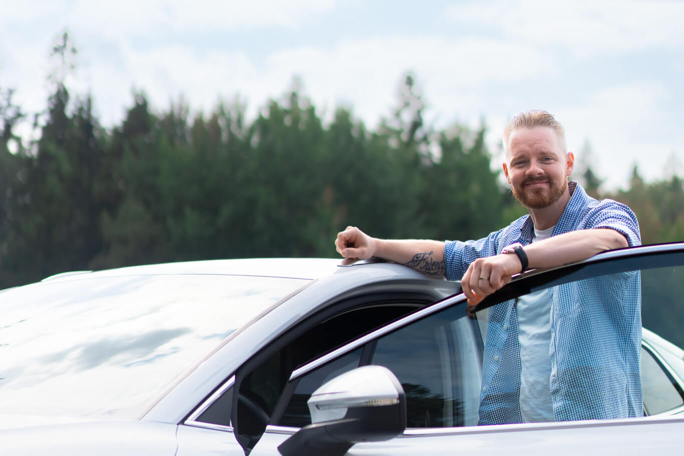 Mies nojaamassa autoonsa.