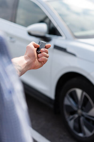 Mies avaamassa autonsa ovien lukitusta.