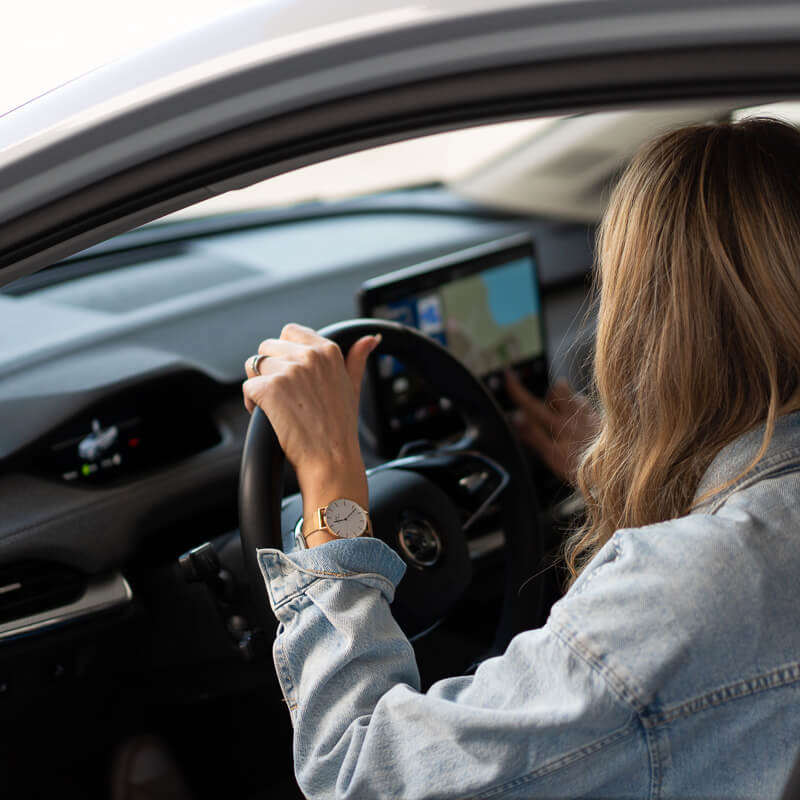 Mies autonsa vieressä iloisena.